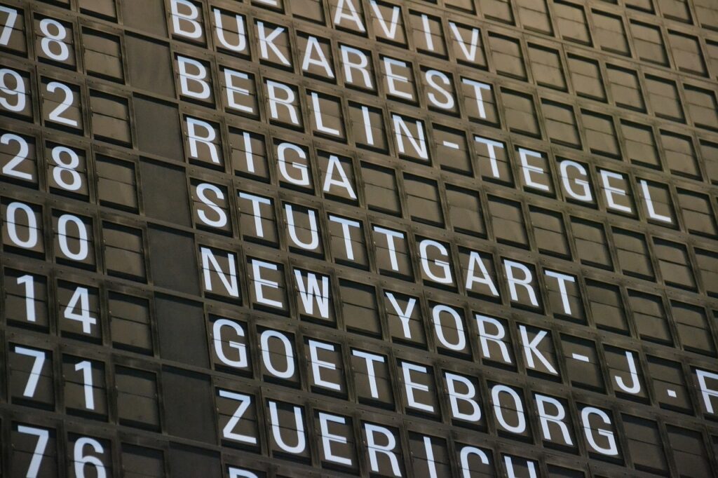 Airport sign partially showing departure times and destination countries